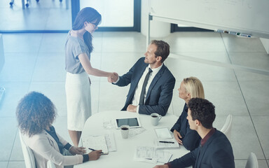 Above, handshake and business people with agreement, hiring and cooperation for project. Employees, shaking hands and group with sales deal, gesture or thank you with feedback, teamwork or contract