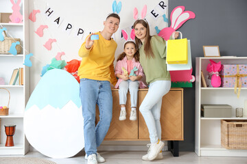 Happy family in bunny ears with credit card and shopping bags at home. Easter Sale