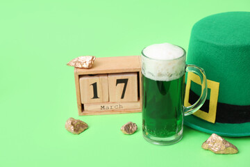 Cube calendar with date 17 MARCH, glass of beer and leprechaun hat on green background. St....