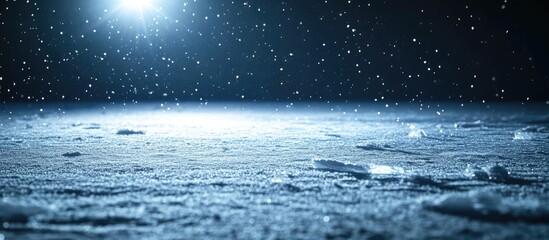 Ice surface with snowflakes softly falling in a dark setting illuminated by a bright spotlight highlighting the textured ice and snow background.