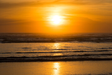 A breathtaking sunset casts warm golden hues over the serene ocean waves, reflecting the day's end and inviting tranquility and introspection amidst nature's beauty.