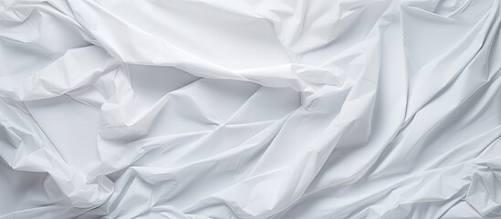 Fototapeta premium Crumpled white paper texture featuring soft folds and shadows in various shades of white, creating a layered and dynamic visual effect.
