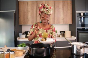 African woman serving traditional Okra Soup with spinach and rice