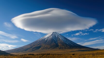 Fototapeta premium A breathtaking view of a majestic volcanic mountain topped with swirling clouds, showcasing the beauty of nature and its dynamic weather formations.