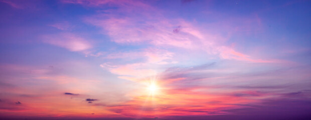 Beautiful sunset sky panorama background with tiny clouds, light rays and other atmospheric effect