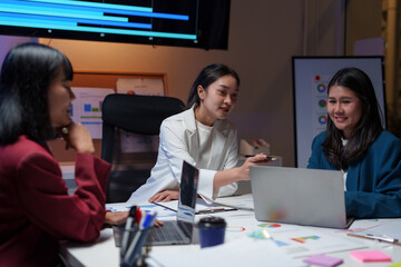 Asian businesswomen working late using laptop in office meeting room