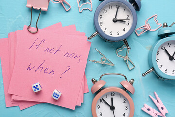 Paper with text IF NOT NOW, WHEN? and alarm clocks on blue background. Time management concept. Top...