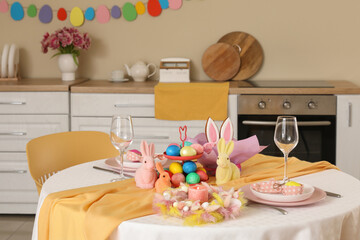 Festive table serving with painted eggs and bunnies for Easter celebration in kitchen