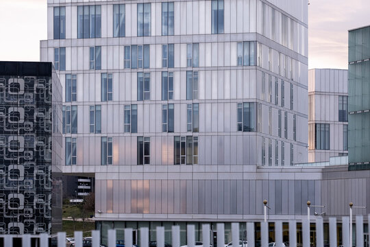 Modern glass building facade with geometric patterns reflecting the urban environment.