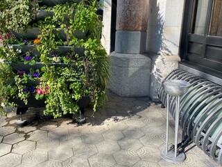 Urban garden corner with lush vertical greenery and sunlight, eco-friendly city design,...