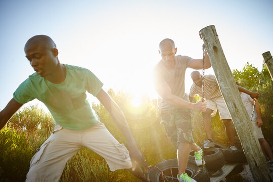 Friends, obstacle course and outdoor for balance, exercise and bootcamp tire beam for endurance. Men, fitness and workout in nature for athlete, health or masculine strength for tough weekend bonding