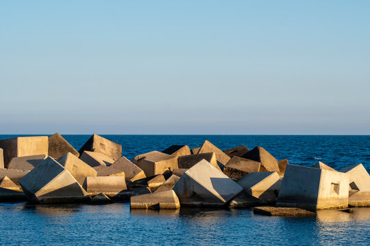 Coastal breakwater made of large angular concrete blocks protecting the shore.