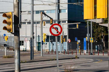 Urban intersection with traffic signs, road markings, and a modern city backdrop.
