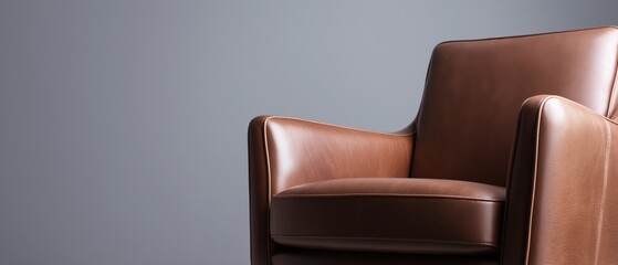Fototapeta premium Close-up of a brown leather armchair. the chair has a modern design with a curved backrest and armrests. the leather appears to be smooth and shiny, and the color is a rich, rich brown.