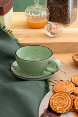 Green mug and saucer on the kitchen table