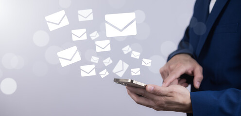 Businessmen use laptops with communication icons, letter icons, email icons, and newsletter email and protect your personal information or spam mail, Customer service call center contact.