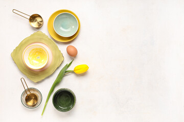 Table setting with Easter eggs and tulip on white background