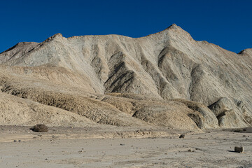 A breathtaking view of a desert mountain range under a clear blue sky, showcasing the stark beauty and unique geology of arid landscapes.
