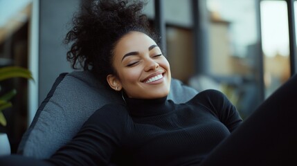 Woman with sleek hair smiles in a relaxed pose on a comfortable couch.