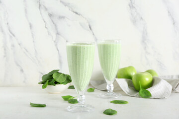 Glasses of fresh spinach smoothie with apple on white background