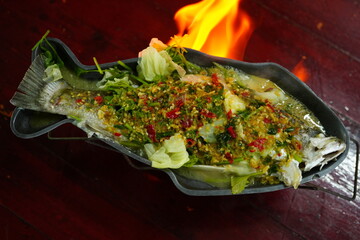 Steamed sea bass with lemon in a fish-shaped tray
