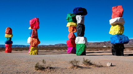 Vibrant and colorful rock sculptures create a whimsical contrast against the stark desert landscape, symbolizing creativity and artistic expression amidst nature.