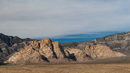A stunning view of rugged rock formations silhouetted against a bright sky, emphasizing the beauty and strength of nature's geological wonders under a vast horizon.