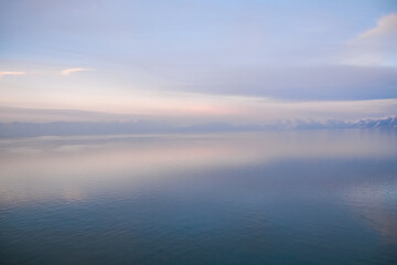 Beautiful sunset over the lake. Sunrise on the sea. Beautiful landscape with lake, mountains and sunset. Reflection in the water