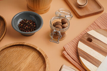 Composition with wooden kitchen utensils and spices on color background