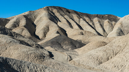 The image captures the undulating hills with fascinating textures and colors, exhibiting the raw beauty of nature's formations in a serene and captivating landscape.