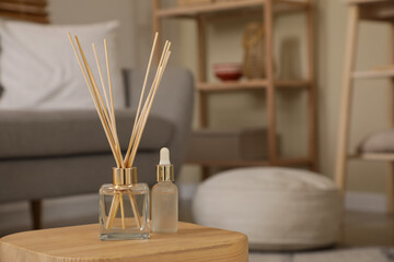 Aroma reed diffuser with essential oil on table in room. Closeup