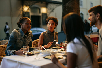 Friends enjoying dinner together at an outdoor restaurant