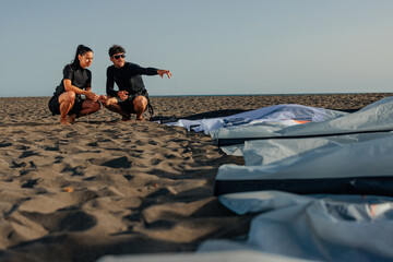 Male kite surfer explaining something to his female teammate