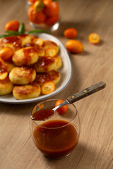 Citrus jam in a glass served with homemade cheese pancakes