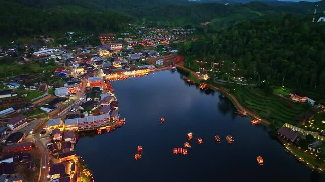 At dusk the reflections of the lights from the village the lake in Chinese-style structures with colorful lights lined the waterfront. Ban Rak Thai is a popular tourist attraction in Mae Hong Son