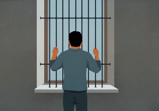 Man behind bars looking out window
