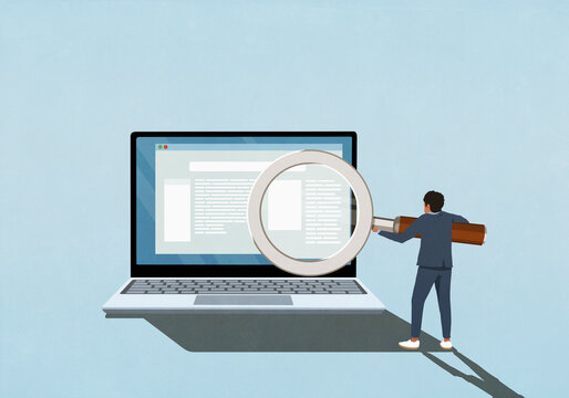 Businessman with magnifying glass reading magnified text on laptop screen
