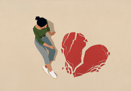 High angle view woman looking down at broken heart
