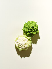 fresh broccoli and cauliflower over beige background