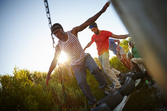 Men, obstacle and outdoor for fitness, exercise and bootcamp tire course for endurance. Friends, training and workout in nature for athlete, health or masculine strength for tough weekend bonding