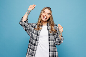 Fototapeta premium Young smiling woman she wears checkered grey shirt casual clothes doing winner gesture celebrate clenching fists dancing isolated on plain pastel light blue cyan background studio. Lifestyle concept.