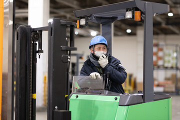 冷蔵倉庫でフォークリフトに乗る男性