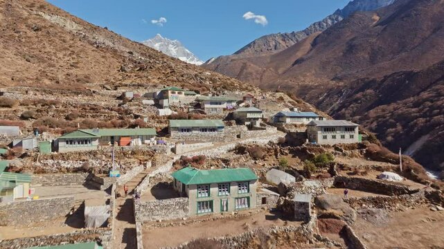 Shomare village, located in the Khumbu region of Nepal, sits amidst a rugged mountainous landscape with Mount Everest towering in the background