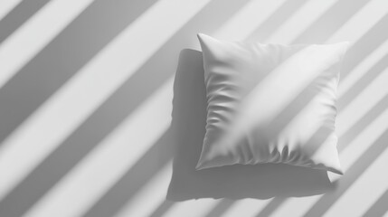 Soft pillow rests on a surface bathed in light and shadow patterns
