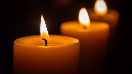 A mesmerizing close-up of flickering candle flames against a dark background, casting warm, dancing shadows that create an intimate and cozy atmosphere