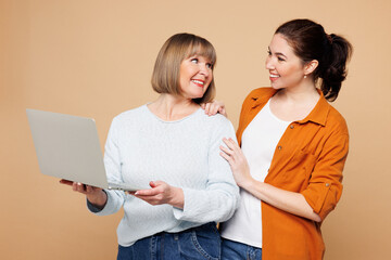 Elder parent mom 50s years old young daughter two IT women together wear casual clothes hold use...
