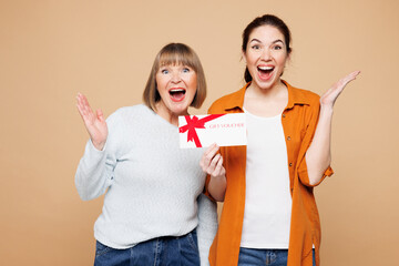 Elder shocked parent mom 50s years old with young adult daughter two women together wear casual...