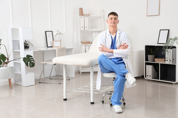 Male medical intern sitting on stool in clinic