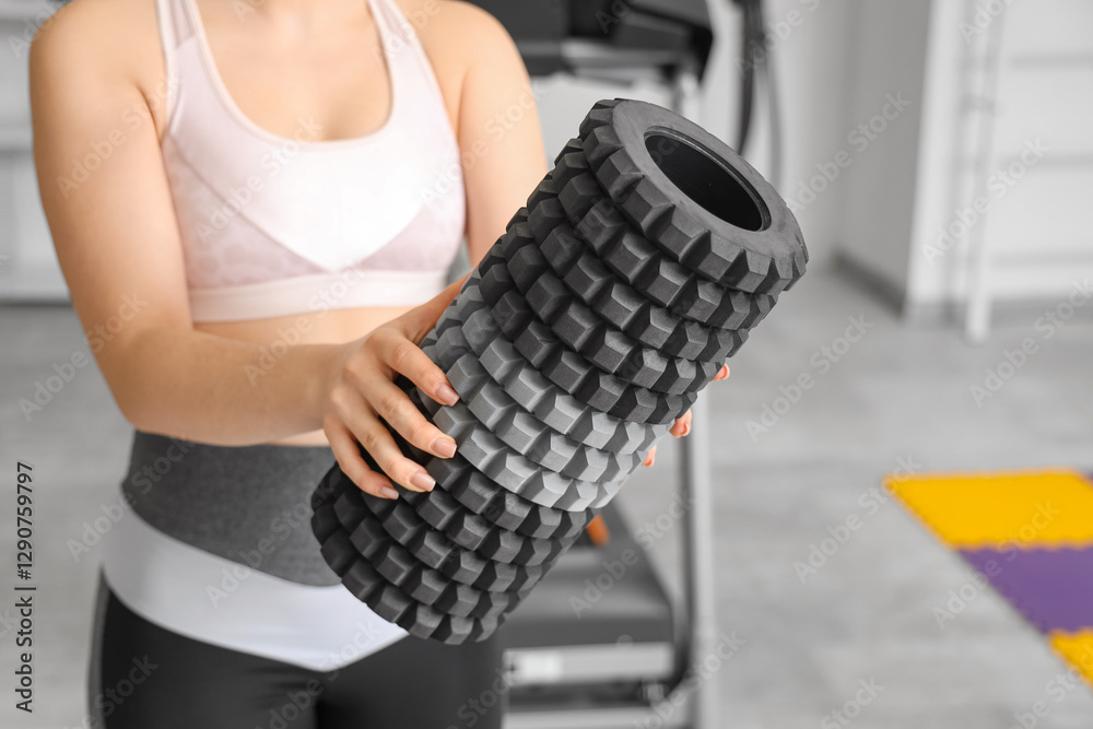 Wall mural Sporty woman with foam roller at gym, closeup