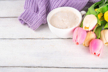 Spring coffee background with flowers and knitted sweater